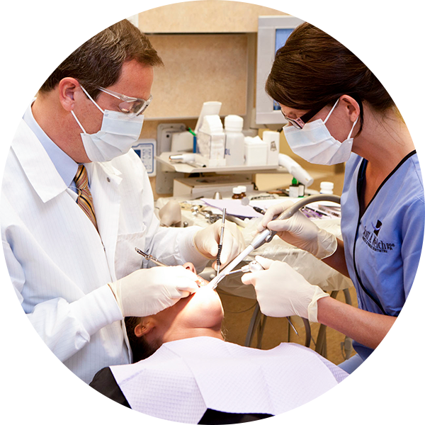 Photo of Dr. Welch checking teeth with dental exam