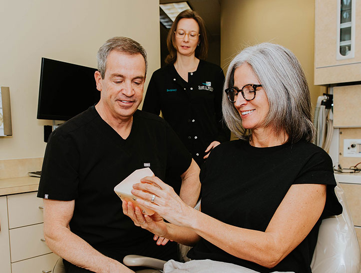 Photo of Dr. Welch giving a patient a dental bridge